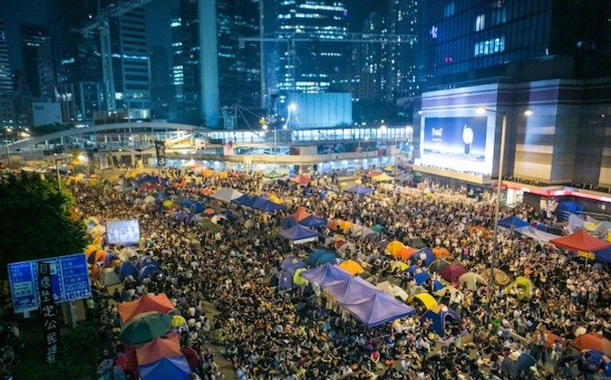 Thousands of pro-democracy protesters attend a rally held by the students leaders after an earlier incident this morning where the police beat protesters with batons, fists, and pepper spray after protesters successfully blocked a road in Hong Kong on Oct. 15, 2014. (Benjamin Chasteen/Epoch Times)