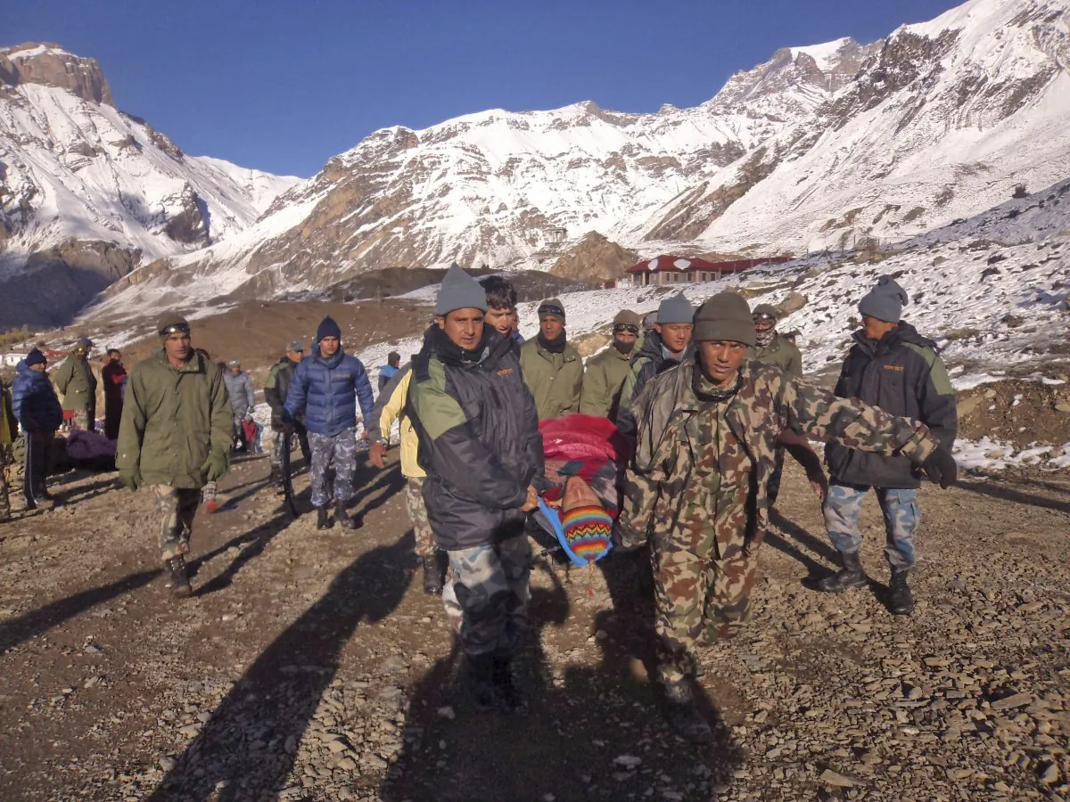 In this photo provided by the Nepalese army, soldiers carry an avalanche victim before he is airlifted in Thorong La pass area, Nepal, Wednesday, Oct. 15, 2014. An avalanche and blizzard in Nepal's mountainous north have killed at least 38 people, including foreign trekkers, officials said Wednesday. (AP Photo/Nepalese Army)