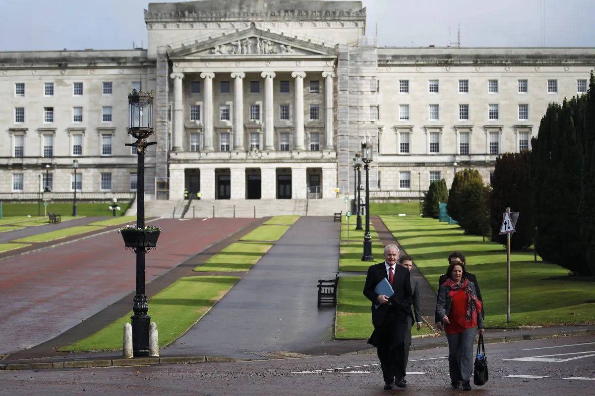 Sinn Fein's Martin McGuinness (F-L) and Jennifer McCann (F-R) walk in front of Stormont Parliamentary Building in Belfast, Northern Ireland, Thursday, Oct. 16, 2014. The main political parties and local leaders are opening negotiations Thursday, to bolster Northern Irelands power-sharing government. The British Prime Minister David Cameron has urged the political figures to reach an agreement to build an effective government for the people of Northern Ireland. (AP Photo/Peter Morrison)