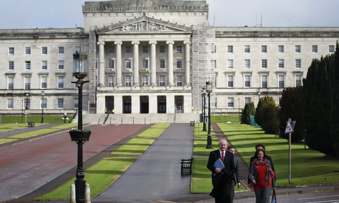 Sinn Fein's Martin McGuinness (F-L) and Jennifer McCann (F-R) walk in front of Stormont Parliamentary Building in Belfast, Northern Ireland, Thursday, Oct. 16, 2014. The main political parties and local leaders are opening negotiations Thursday, to bolster Northern Irelands power-sharing government. The British Prime Minister David Cameron has urged the political figures to reach an agreement to build an effective government for the people of Northern Ireland. (AP Photo/Peter Morrison)