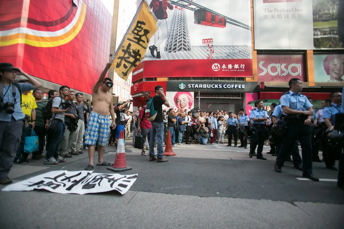 Police and pro-democracy protesters stand off on a small section of Nathan Road after the police came in early in the morning and removed all of the barriers in the surrounding areas in Mong Kok, Hong Kong, on Oct. 17, 2014. (Benjamin Chasteen/Epoch Times)