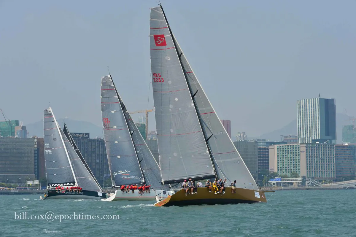 Boats ‘FreeFire’, ‘Team Beau Geste’ and ‘One Sails East’ with the sail of ‘mandrake 3’ in the background leaving the start line in Victoria Harbor on Thursday Oct 16, 2014 in the Hong Kong to Hainan race.
(Bill Cox/Epoch Times)