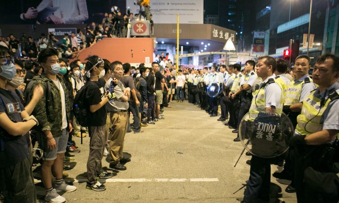 Pro-democracy protesters stand off with the police after they were trying all night to shutdown parts of Argyle Street and Nathan Road in Mong Kok, Hong Kong, on Oct. 18, 2014. (Benjamin Chasteen/Epoch Times)