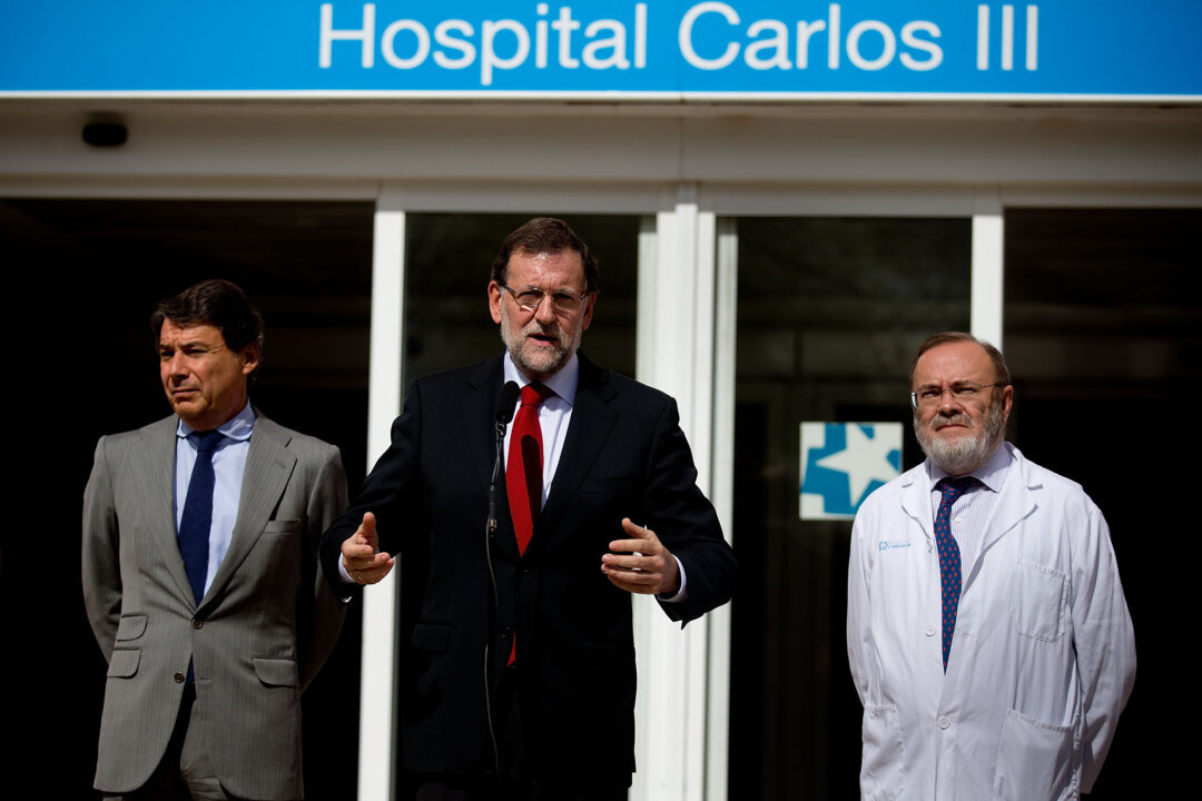Spanish Prime Minister Mariano Rajoy (C) gives a speech at the front door of Carlos III hospital, watched by Madrid Regional President Ignacio Gonzalez (L) and Carlos III hospital manager Rafael Perez Santamarina (R) where nurse Teresa Romero is being treated for the Ebola virus on Oct. 10, 2014, in Madrid, Spain. Spanish Health Minister Ana Mato confirmed nurse Teresa Romero had tested positive after treating two Ebola patients that had been brought back to the country from Africa. (Gonzalo Arroyo Moreno/Getty Images)