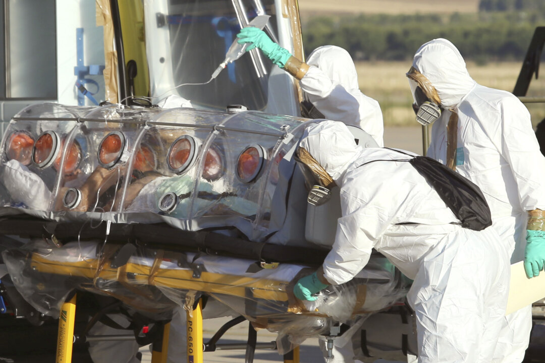 Aid workers and doctors transfer Miguel Pajares, a Spanish priest who was infected with the Ebola virus while working in Liberia, from a plane to an ambulance as he leaves the Torrejon de Ardoz military airbase, near Madrid, Spain, on Aug. 7, 2014. Comparisons between Ebola and AIDS have surfaced in mid-2014 as the Ebola outbreak escalated. But Ebola is not expected to ever be in the same league as AIDS in terms of infections and deaths, said Dr. Anthony Fauci, director of the National Institute of Allergy and Infectious Diseases. (AP Photo/Spanish Defense Ministry, File)