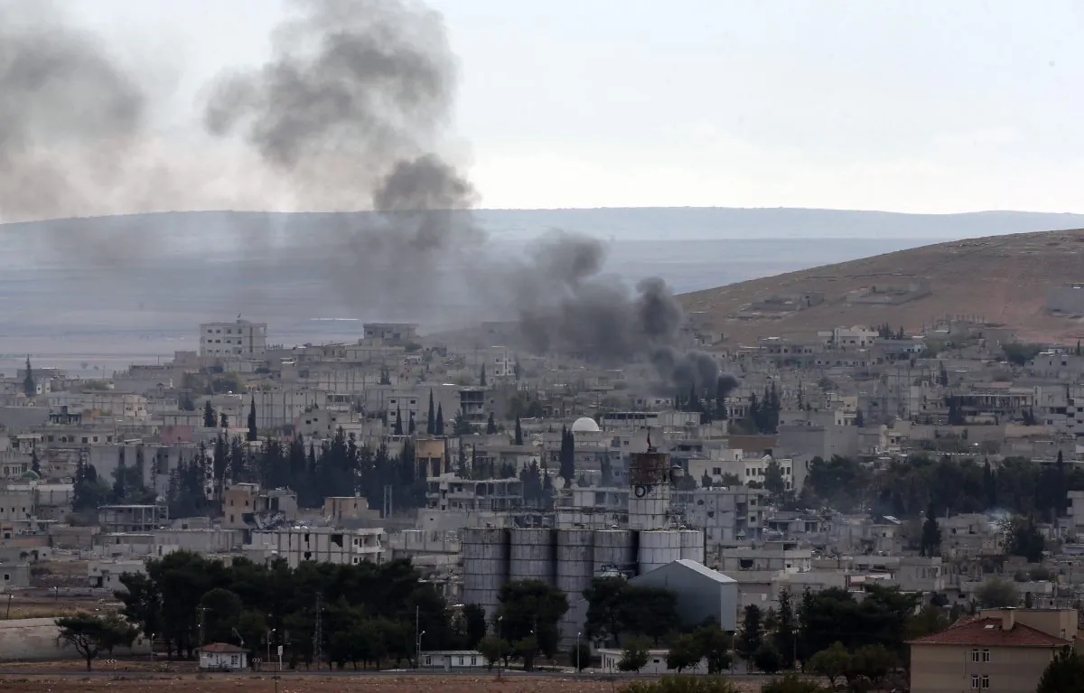 Smoke from a fire rises in Kobani, Syria, while fighting continued between Syrian Kurds and the militants of the Islamic State group, as seen from Mursitpinar on the outskirts of Suruc, at the Turkey-Syria border, Saturday, Oct. 18, 2014. Kobani, also known as Ayn Arab, and its surrounding areas, has been under assault by extremists of the Islamic State group since mid-September and is being defended by Kurdish fighters. (AP Photo/Lefteris Pitarakis)