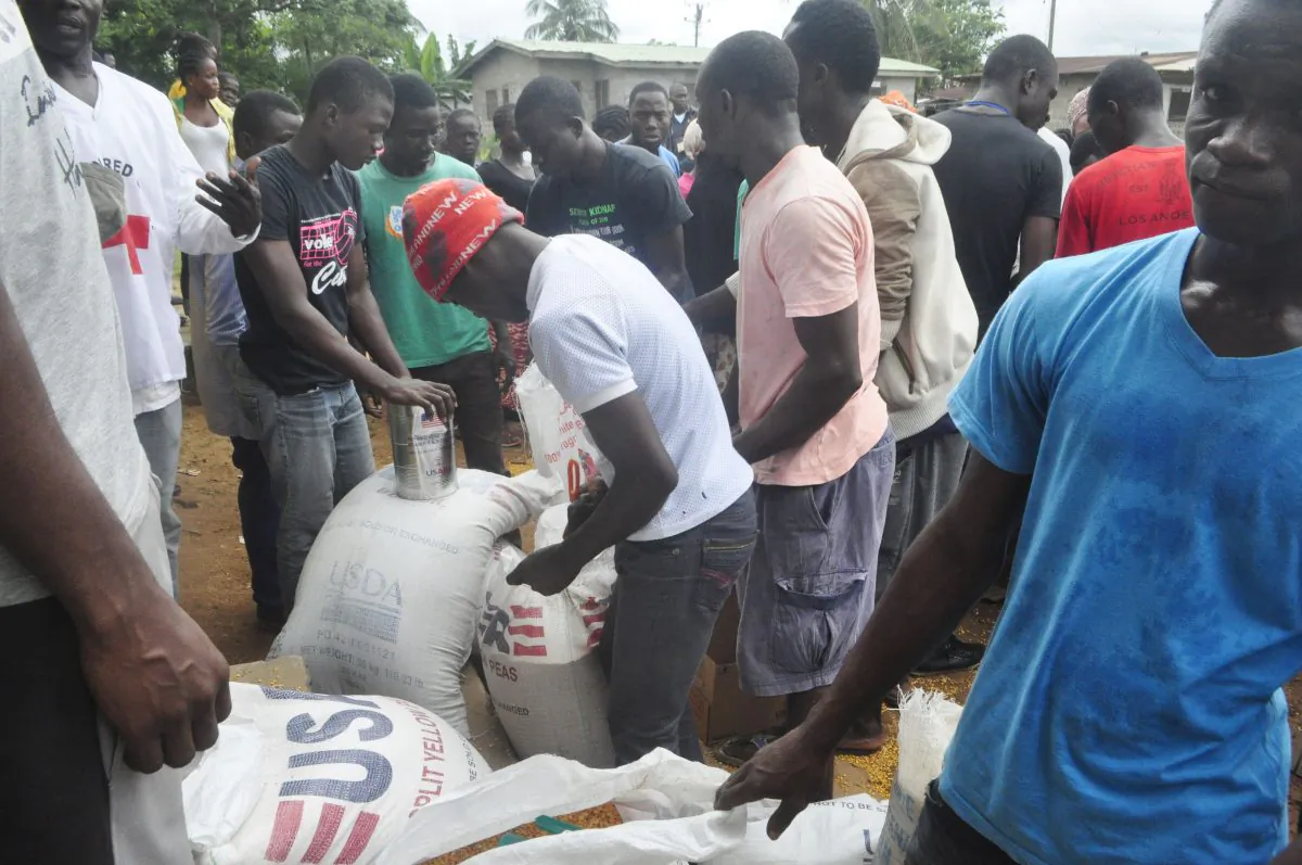 People from a community affected by Ebola virus receive food aid from World Food program in Monrovia, Liberia, on Oct, 15, 2014. The UN's World Food Program is also delivering emergency food rations to 265,000 people in Sierra Leones capital to help fight the spread of Ebola. (AP Photo/Abbas Dulleh)