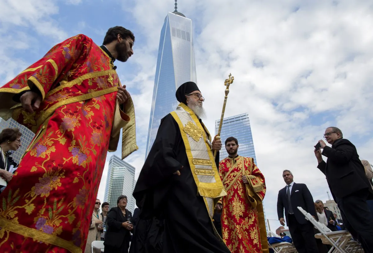 With One World Trade Center in the background, people gather (front) for a groundbreaking ceremony at the site of the St. Nicholas National Shrine in New York, Saturday, Oct. 18, 2014. The groundbreaking event marked a new beginning for the former St. Nicholas Greek Orthodox Church, the only house of worship destroyed during the 9/11 attacks. (AP Photo/Craig Ruttle)
