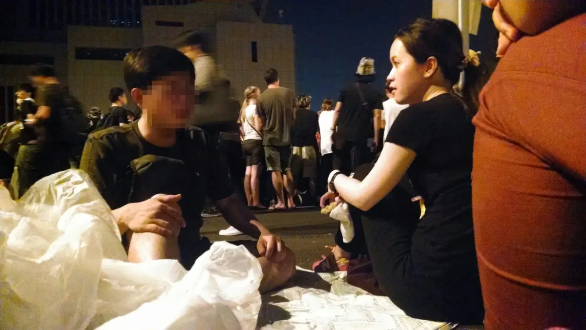 A young mainland Chinese man (left) discusses competing ideas on Hong Kong's democracy with a local Hong Kong woman on Oct. 4, 2014. The occupy movement in Hong Kong has taken over key roads around government offices in an effort to push for greater democracy. (Matthew Robertson/Epoch Times)
