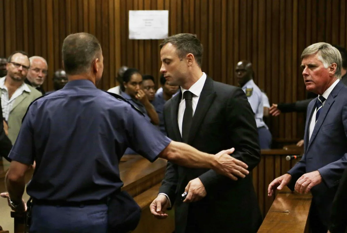 Oscar Pistorius, center, is led out of court in Pretoria, South Africa, Tuesday, Oct. 21, 2014.  Pistorius received a five-year prison sentence for culpable homicide by judge Thokozile Masipais for the killing of his girlfriend Reeva Steenkamp last year (AP Photo/Themba Hadebe)