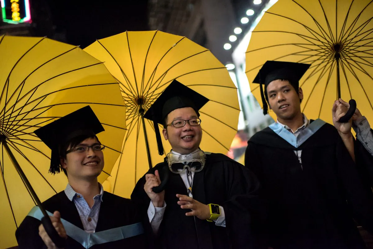 College students in graduation attire carry yellow umbrellas, symbols of the pro-democracy movement in Hong Kong, as they pose for photos in the Mongkok district of Hong Kong on Oct. 19, 2014. Dozens of students held umbrellas during their graduation ceremony at Lingnan University in Hong Kong to urge the head of the school to host talks between the chief executive and the pro-democracy students fairly. (Alex Ogle/AFP/Getty Images)