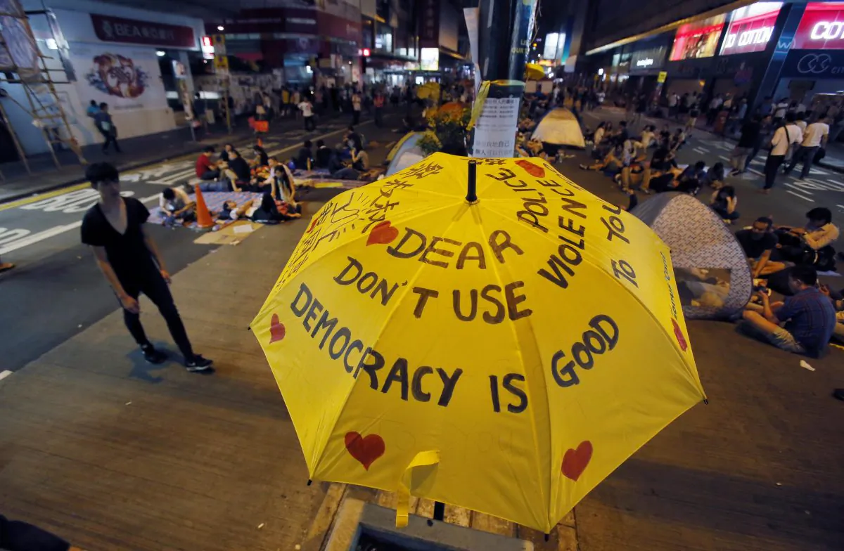 An umbrella, which has become an icon of the protest, reads pro-democracy messages above the student-led protest site in the Mong Kok district of Hong Kong, Monday, Oct. 20, 2014. (AP Photo/Wally Santana)