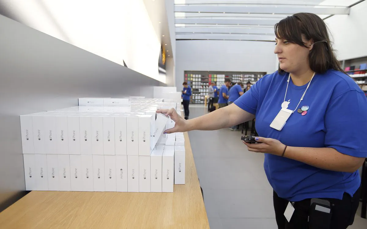 An Apple employee grabs an iPhone 6 for a customer at the Apple Store during the launch and sale of the new iPhone 6 and 6 Plus smartphones, in Palo Alto, Calif., on Sept. 19, 2014. Apple on Monday, Oct. 20, 2014 said it sold 39.3 million iPhones in the last quarter, or 16 percent more than a year ago, which is a record for the quarter. That’s partly due to excitement over new iPhone 6 and 6 Plus models that Apple began selling last month. (AP Photo/Tony Avelar)
