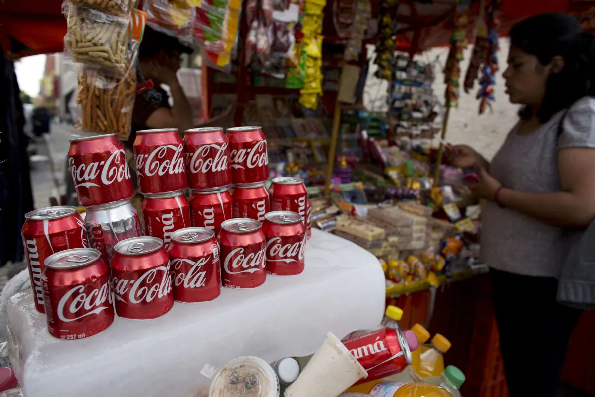 Cans of Coca-Cola sit on an ice block to keep cool at a street vendor's stand in Mexico City on Oct. 9, 2014. (Rebecca Blackwell/AP Photo)