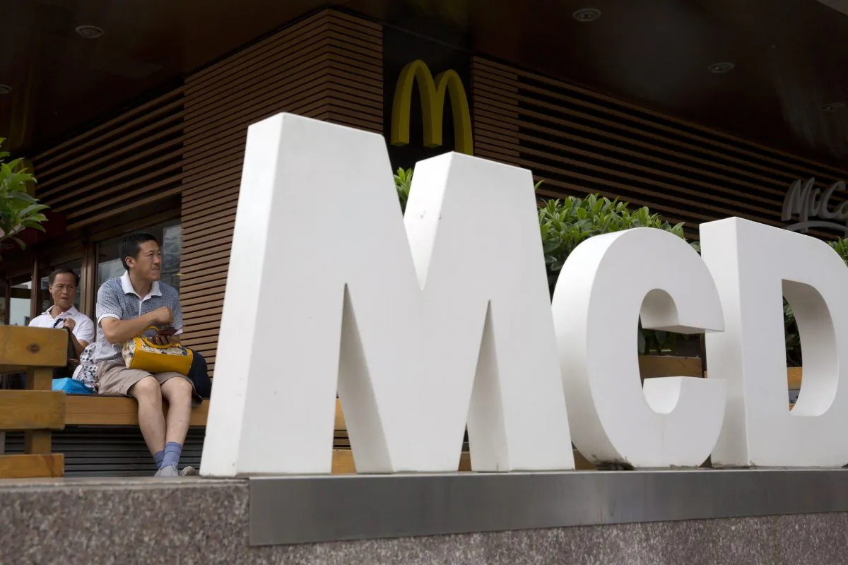 A man rests outside a McDonald's restaurant in Beijing on July 22, 2014. McDonald's reports quarterly financial results on Tuesday, Oct. 21, 2014. (AP Photo/Ng Han Guan)