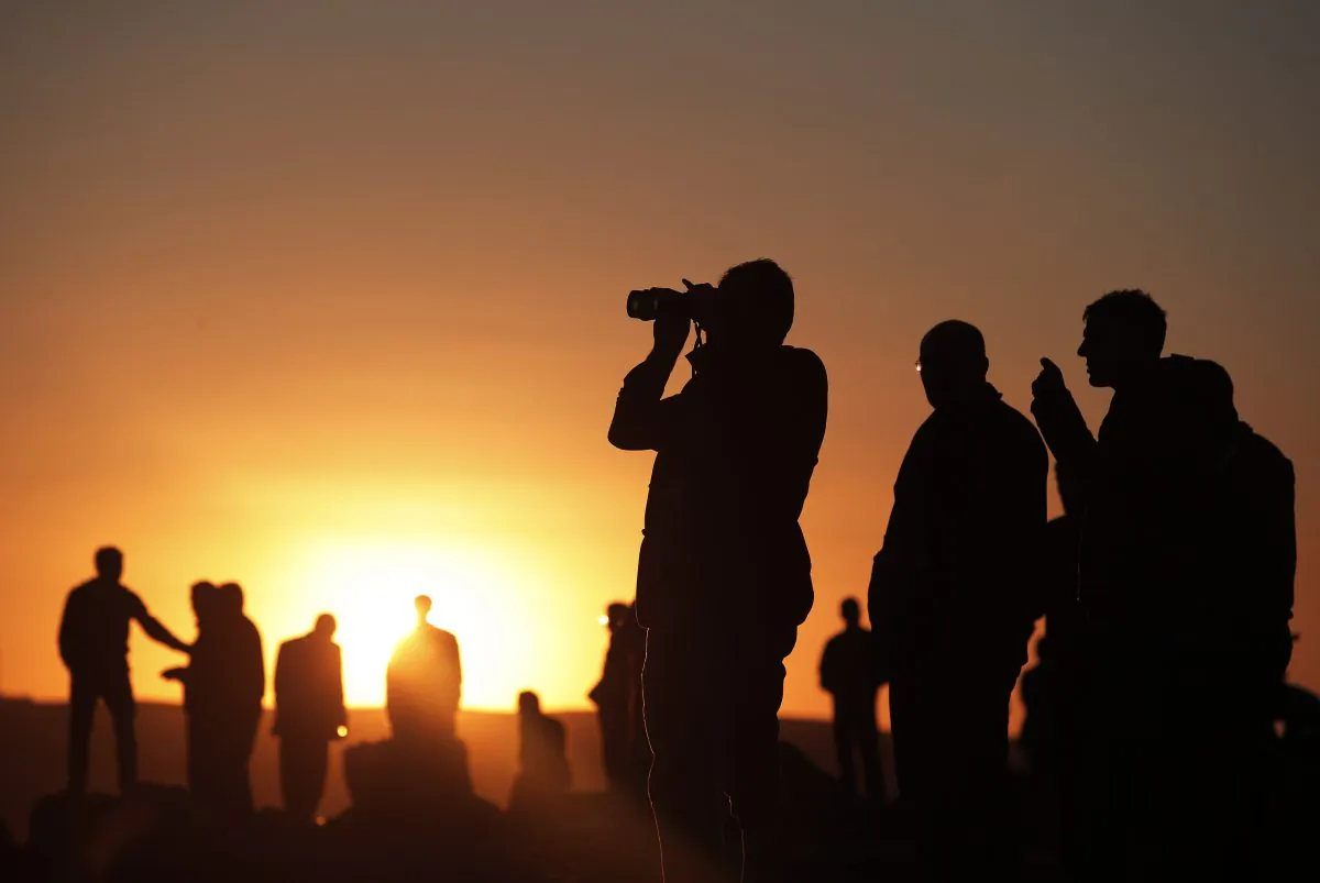 People gather on a hilltop on the outskirts of Suruc, at the Turkey-Syria border, to watch in the distance the fighting between Syrian Kurds and the militants of Islamic State group in Kobani, Syria, Tuesday, Oct. 21, 2014. Kobani, also known as Ayn Arab, and its surrounding areas, has been under assault by extremists of the Islamic State group since mid-September and is being defended by Kurdish fighters. (AP Photo/Lefteris Pitarakis)