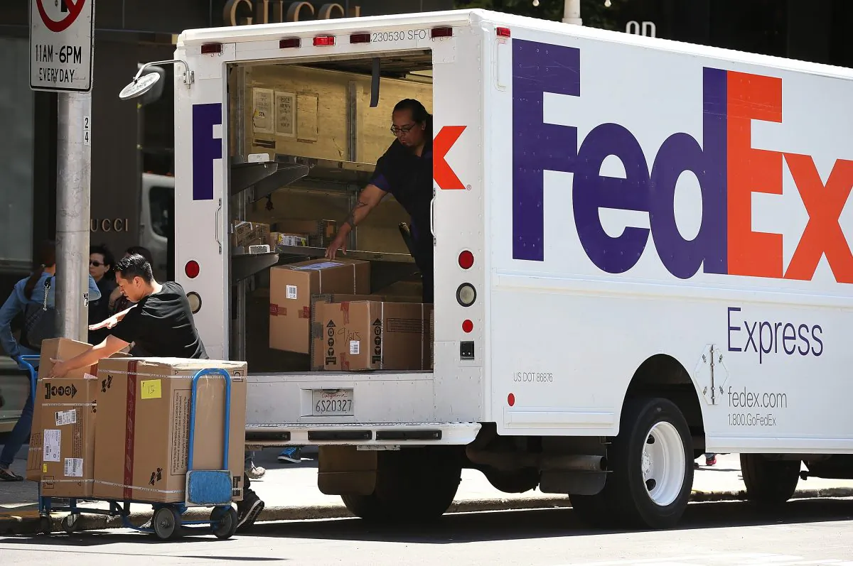 FedEx workers unload packages from a delivery truck on June 19, 2013, in San Francisco, California. (Justin Sullivan/Getty Images)