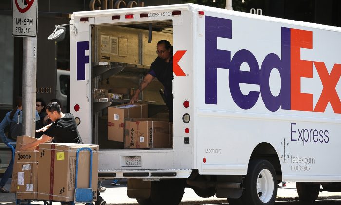 FedEx workers unload packages from a delivery truck on June 19, 2013, in San Francisco, California. (Justin Sullivan/Getty Images)