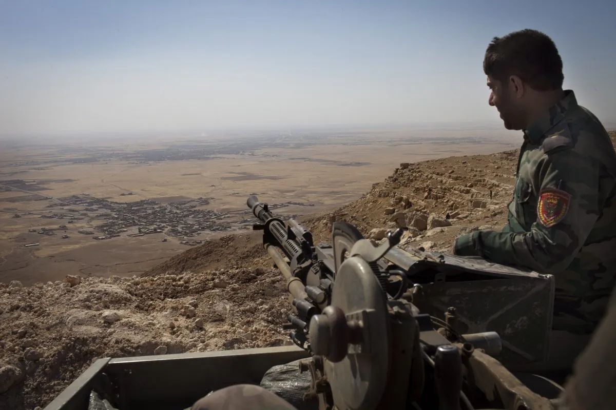 An Iraqi Kurdish Peshmerga fighter hold his position on the top of Mount Zardak, a strategic point about 25 kilometres east of Mosul, on Sept. 9, 2014. (J.M. Lopez/AFP/Getty Images)