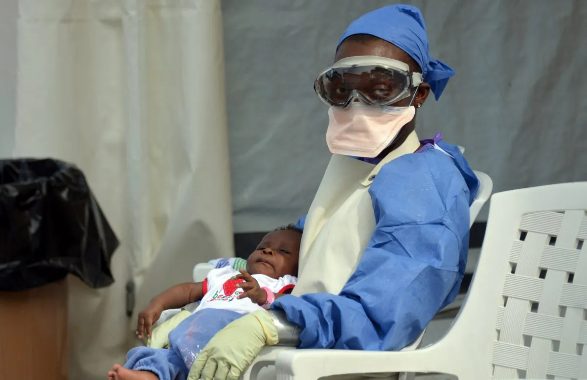 A Liberian health worker holds a baby infected with the Ebola virus on Oct. 18, 2014, at the NGO Medecins Sans Frontieres (Doctors Without Borders) Ebola treatment center in Monrovia. The death toll in the world's worst-ever Ebola outbreak has shot past 4,800, killing at least half of the more than 9,900 people infected. (Zoom Dosso/AFP/Getty Images)