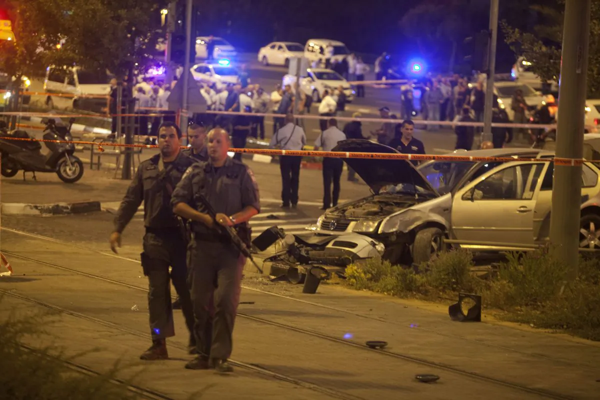 Israeli policemen stand guard at the scene after a car rammed a group of pedestrians near the light rail train station near Ammunition Hill in Jerusalem, Israel, on Oct. 22, 2014. A three-month baby was killed and several people were wounded on Wednesday evening in a suspected terror attack near the light rail train station near Ammunition Hill in Jerusalem. According to eyewitnesses, a car drove up to the station and ran over passersby disembarking from the train. (Lior Mizrahi/Getty Images)