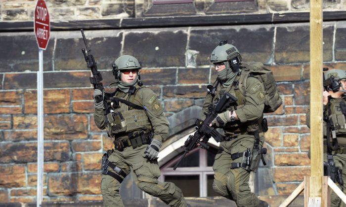 A Royal Canadian Mounted Police intervention team responds to a reported shooting at Parliament building in Ottawa, Wednesday, Oct. 22, 2014. (AP Photo/The Canadian Press, Adrian Wyld)
