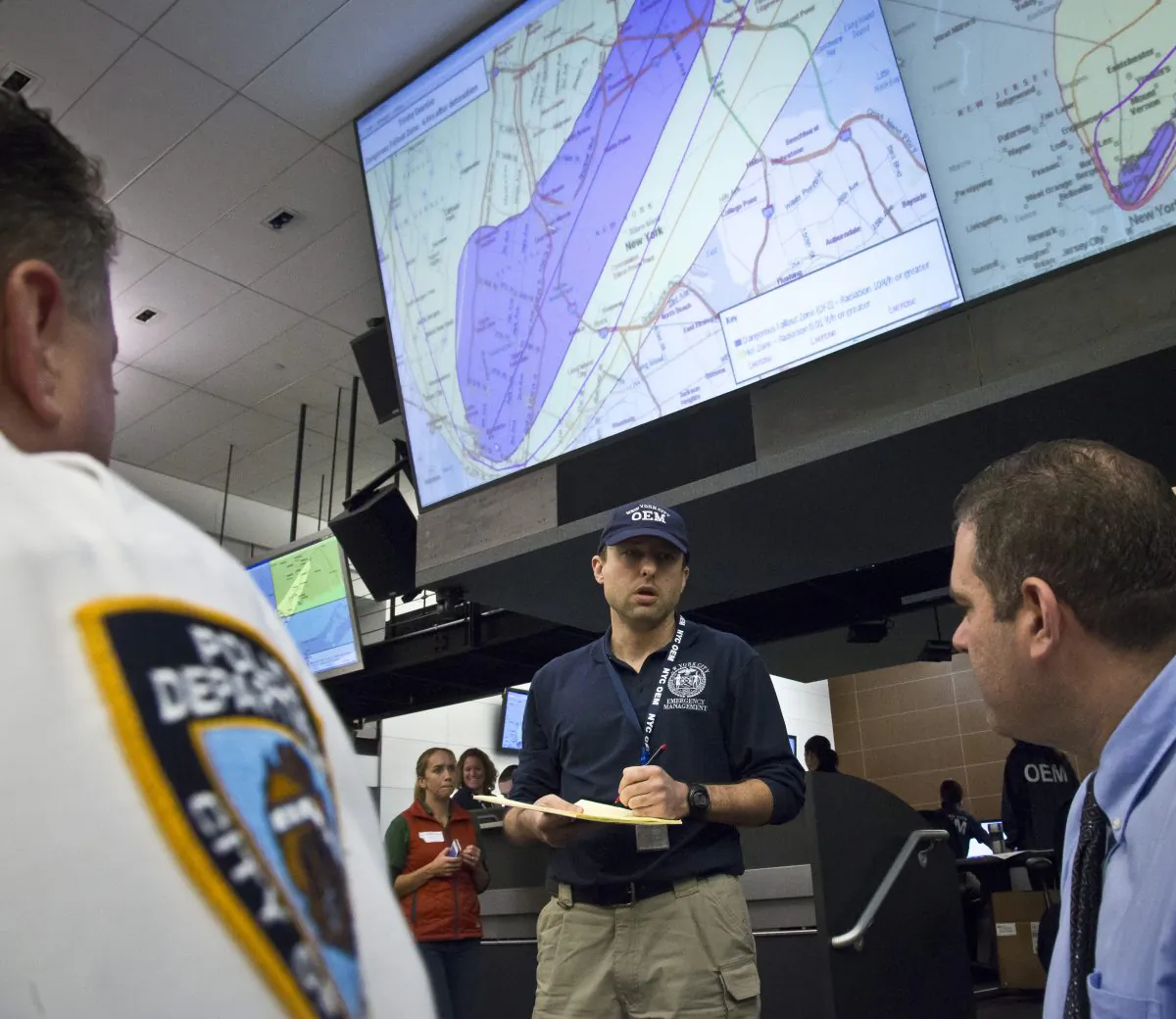 John Case, center, a watch commander with New York's Office of Emergency Management (OEM) collect information from officials, during an "Emergency Management Catastrophic Exercise Program" on Wednesday Oct. 22, 2014, in New York.  The exercise simulated a nuclear explosion in New York's Manhattan and the coordination of regional emergency and law enforcement officials to manage the aftermath.  (AP Photo/Bebeto Matthews)