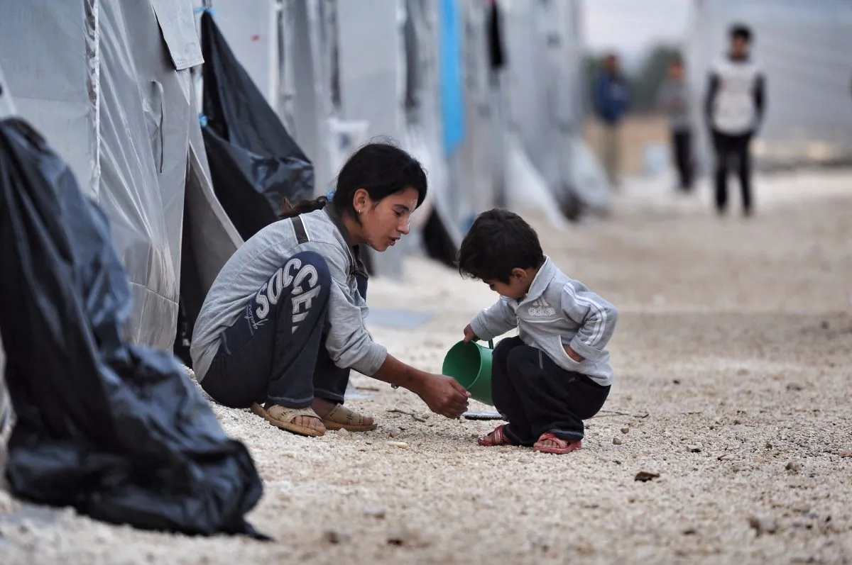 A Kurdish refugee boy from the Syrian town of Kobani helps his sister to wash her face in front of a family tent in a camp on Oct. 23, 2014, in southeastern town of Suruc, Sanliurfa province. The Syrian town of Kobani has yet again seen fierce fighting between Islamic State and Syrian Kurdish forces. Kurdish authorities have agreed to send Peshmerga fighters to the Northern Syrian town to fight ISIL after Turkey has allowed passage. (Kutluhan Cucel/Getty Images)