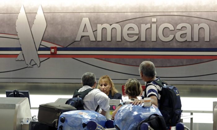 Passengers check in at the American Airlines counter at Miami International Airport in Miami on May 27, 2014. American Airlines reports quarterly financial results on Thursday, Oct. 23, 2014. (AP Photo/Alan Diaz)