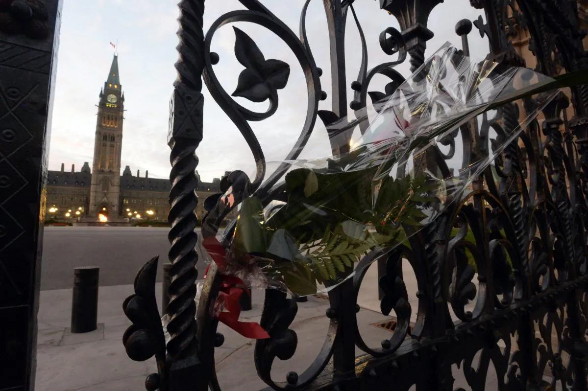 A rose rests in the main gate of Parliament Hill in Ottawa on Thursday, Oct. 23, 2014. Cpl. Nathan Cirillo was killed Wednesday at the National War Memorial by a gunman who then raced to Parliament Hill, where he was killed in a gunfight in the halls of the Centre Block. (AP Photo/The Canadian Press, Adrian Wyld)