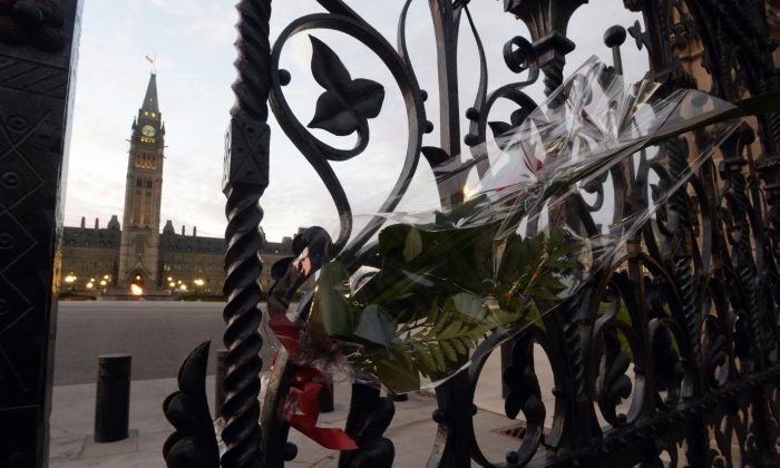 A rose rests in the main gate of Parliament Hill in Ottawa on Thursday, Oct. 23, 2014. Cpl. Nathan Cirillo was killed Wednesday at the National War Memorial by a gunman who then raced to Parliament Hill, where he was killed in a gunfight in the halls of the Centre Block. (AP Photo/The Canadian Press, Adrian Wyld)
