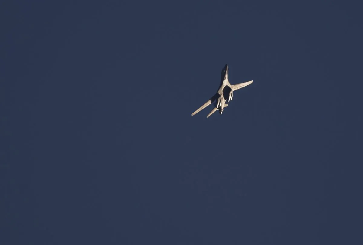 A military aircraft circles above Kobani, Syria, seen from a hilltop on the outskirts of Suruc, at the Turkey-Syria border, Thursday, Oct. 23, 2014. Kobani, also known as Ayn Arab, and its surrounding areas, has been under assault by extremists of the Islamic State group since mid-September and is being defended by Kurdish fighters. (AP Photo/Vadim Ghirda)