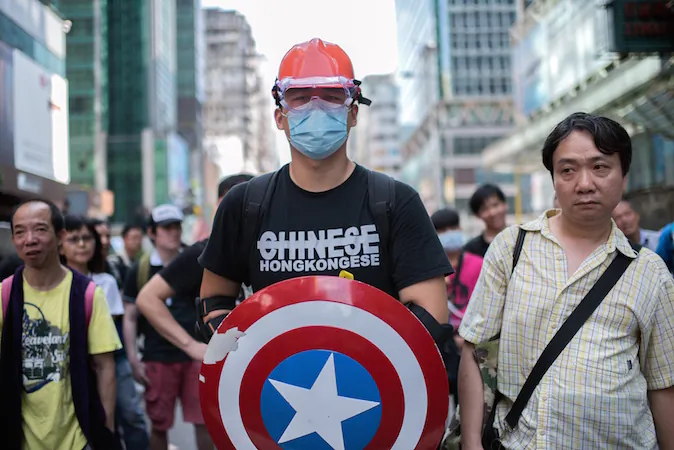 A man wearing protective gear and carrying a shield from the "Captain America" comic book series stands guard next to a pro-democracy protest barricade in the Mongkok district of Hong Kong on Oct. 19, 2014. (Alex Ogle/AFP/Getty Images)