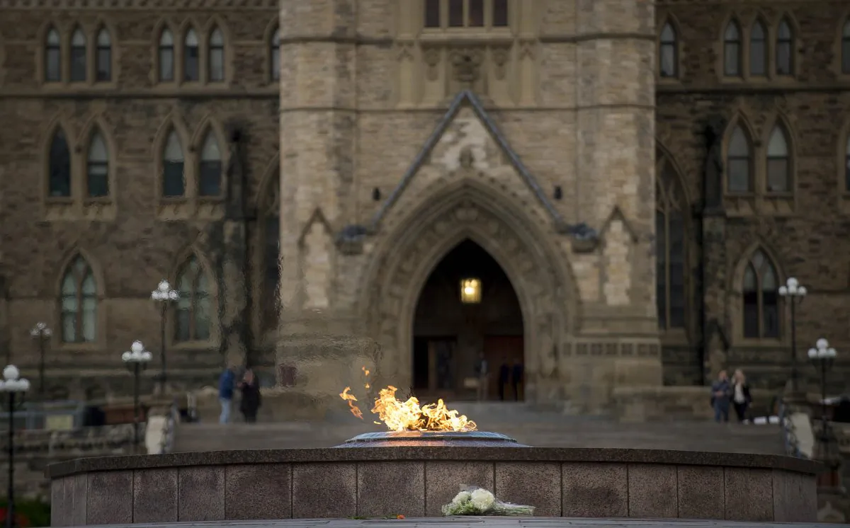 A bouquet of flowers sits in front of the eternal flame in front of Canada's House of Parliament in Ottawa, on Oct. 23, 2014, one day after multiple shootings in the capital city and Parliament buildings left a soldier dead and others wounded. (Peter McCabe/AFP/Getty Images)