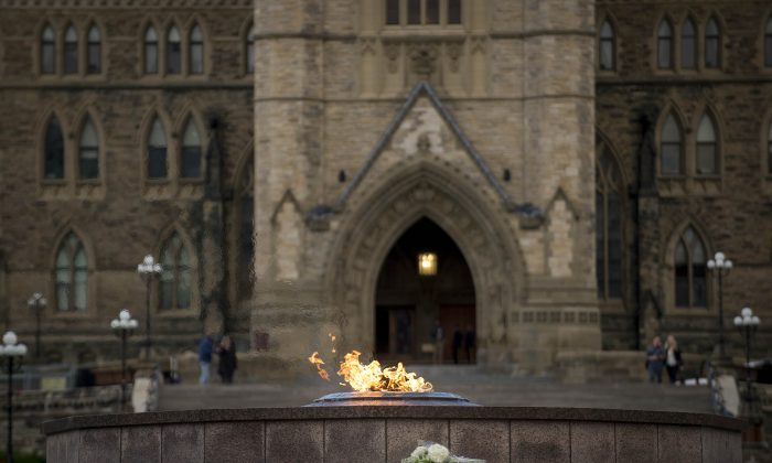 A bouquet of flowers sits in front of the eternal flame in front of Canada's House of Parliament in Ottawa, on Oct. 23, 2014, one day after multiple shootings in the capital city and Parliament buildings left a soldier dead and others wounded. (Peter McCabe/AFP/Getty Images)