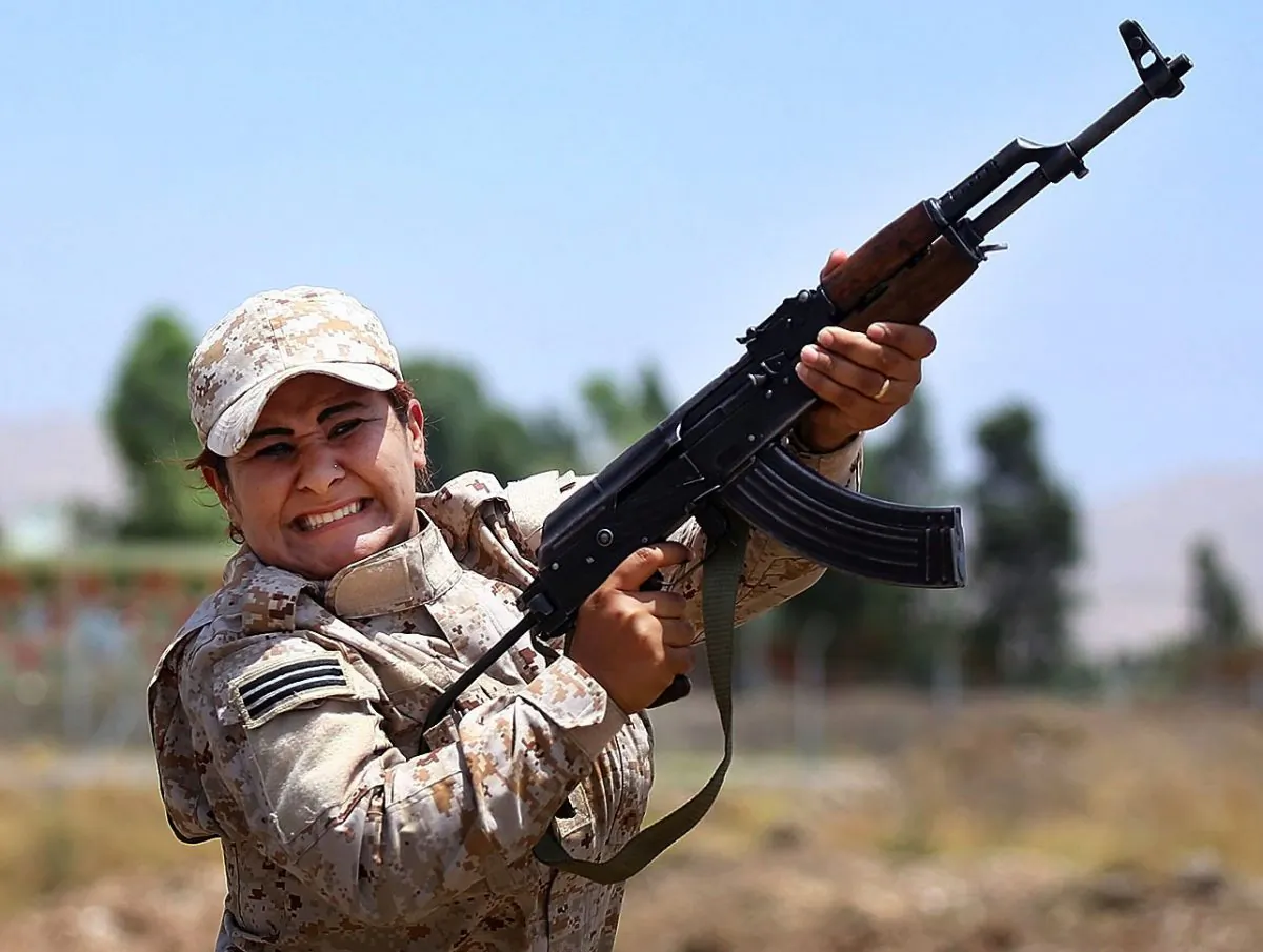 In this Thursday, July 3, 2014 photo, a member of an elite unit of women Kurdish Peshmerga fighters trains in Sulaimaniyah, 160 miles (260 kilometers) northeast of Baghdad, Iraq. Among the Kurdish fighters defending the Syrian town of Kobani against the IS are thousands of women. In April, Kurdish fighters created all-female combat units that have grown to include more than 10,000 women who played a major role in battles against IS, said Nasser Haj Mansour, a defense official in Syria's Kurdish region. (AP Photo)