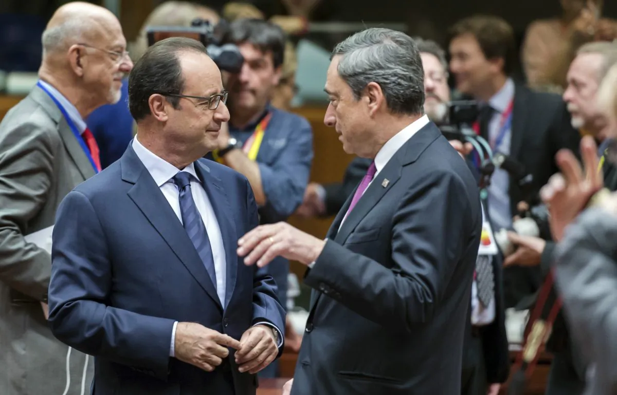 French President Francois Hollande (L) speaks with European Central Bank Governor Mario Draghi (R) during a round table meeting at an EU summit in Brussels on Friday, Oct. 24, 2014. Britain says its prime minister, David Cameron, is protesting a European Union request for an additional 2.1 billion euro ($2.65 billion) contribution to the EU coffers at a time of increasing pressure at home for the country to leave the bloc. (AP Photo/Geert Vanden Wijngaert)