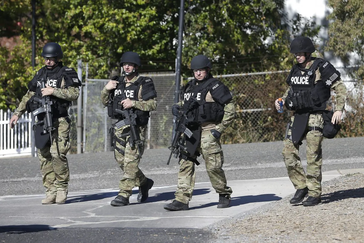 Law enforcement officers dressed in tactical gear leave the Gold County Fairgrounds to help in the search of an assailant, in Auburn, Calif., who shot three sheriff's deputies in two Northern California Counties, Friday, Oct. 24, 2014.  (AP Photo/Rich Pedroncelli)