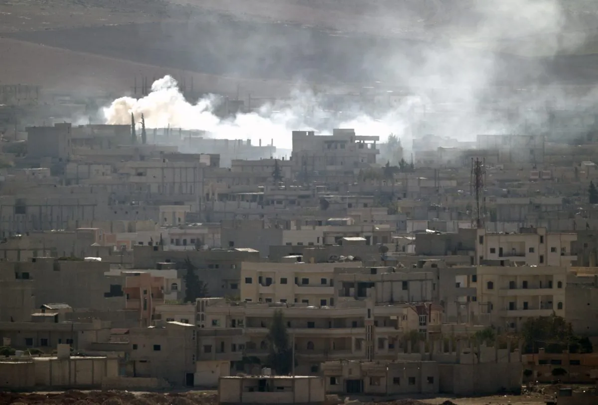 Smoke rises during fighting in Kobani, seen from a hilltop on the outskirts of Suruc, near the Turkey-Syria border, Friday, Oct. 24, 2014. Kobani, also known as Ayn Arab, and its surrounding areas, has been under assault by extremists of the Islamic State group since mid-September and is being defended by Kurdish fighters. (AP Photo/Vadim Ghirda)