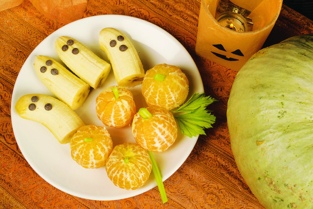 Having your children help make banana ghosts and tangerine jack-o-lanterns will get them excited to eat healthier treats. (hemeroskopion/iStock/Thinkstock)