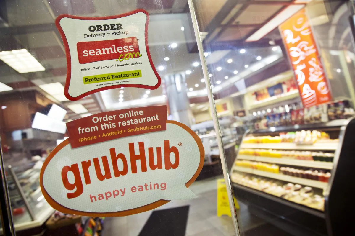 A GrubHub sticker in front of a New York restaurant, on April 4, 2014, lets consumers know that food ordering is available online and in mobile. (AP Photo/Mark Lennihan)
