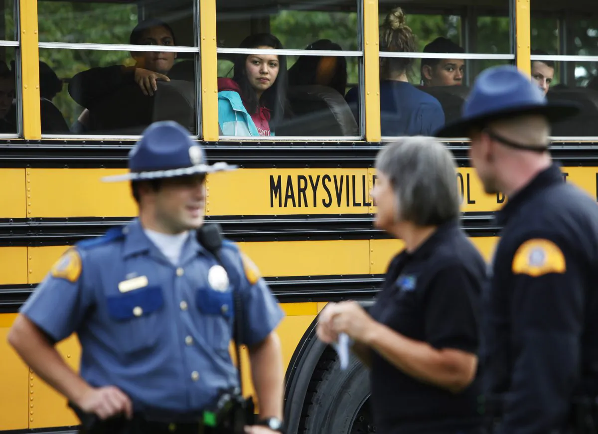 Marysville-Pilchuck students are bussed from the high school to the nearby Shoultes Christian Assembly Church where they were reunited with their families after a school shooting took place Friday, Oct. 24, 2014. A student walked into his Seattle-area high school cafeteria on Friday and without shouting or arguing, opened fire, killing one person and shooting several others in the head before turning the gun on himself, officials and witnesses said. (AP Photo/The Herald, Genna Martin)