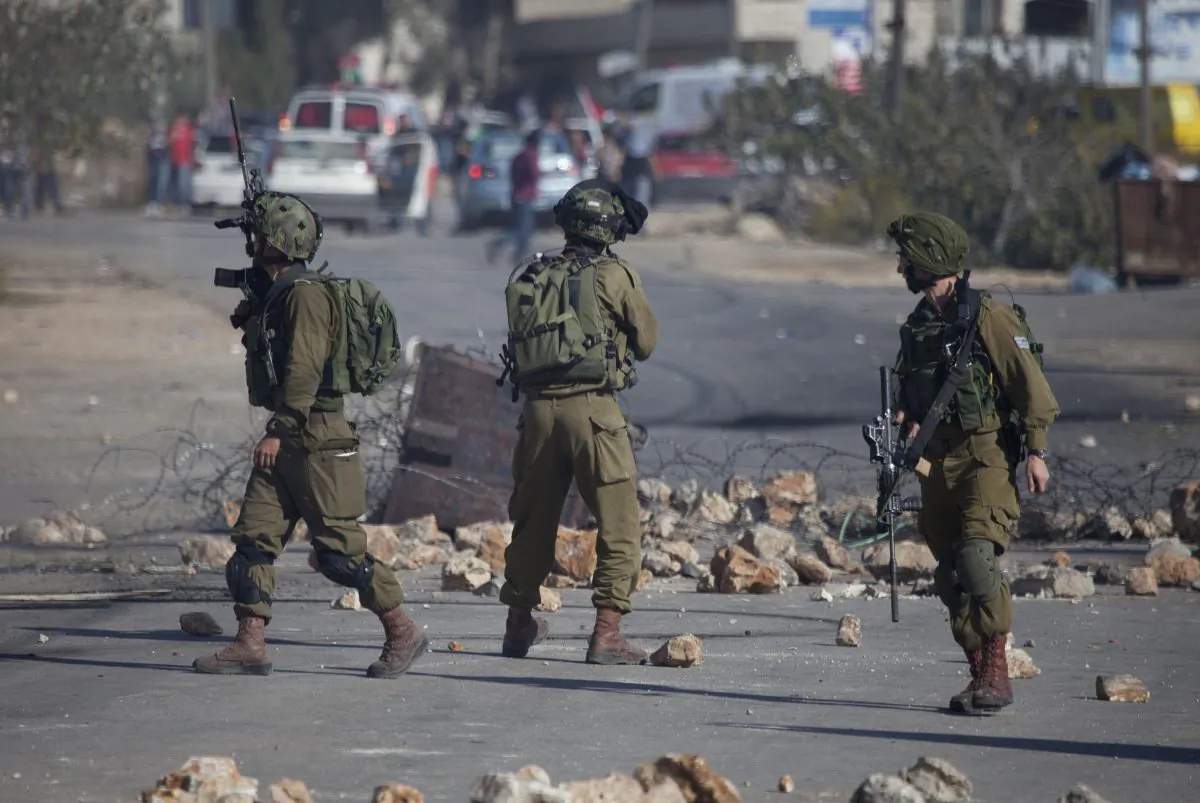 Israeli soldiers fire rubber bullets towards Palestinian protesters during clashes with Israeli security forces after the funeral Palestinian-American, Orwah Hammad, 14, who was shot dead last Friday during clashes with Israeli army soldiers, at the entrance of Hammad's home village of Silwad, near the West Bank city of Ramallah. (AP Photo/Majdi Mohammed)