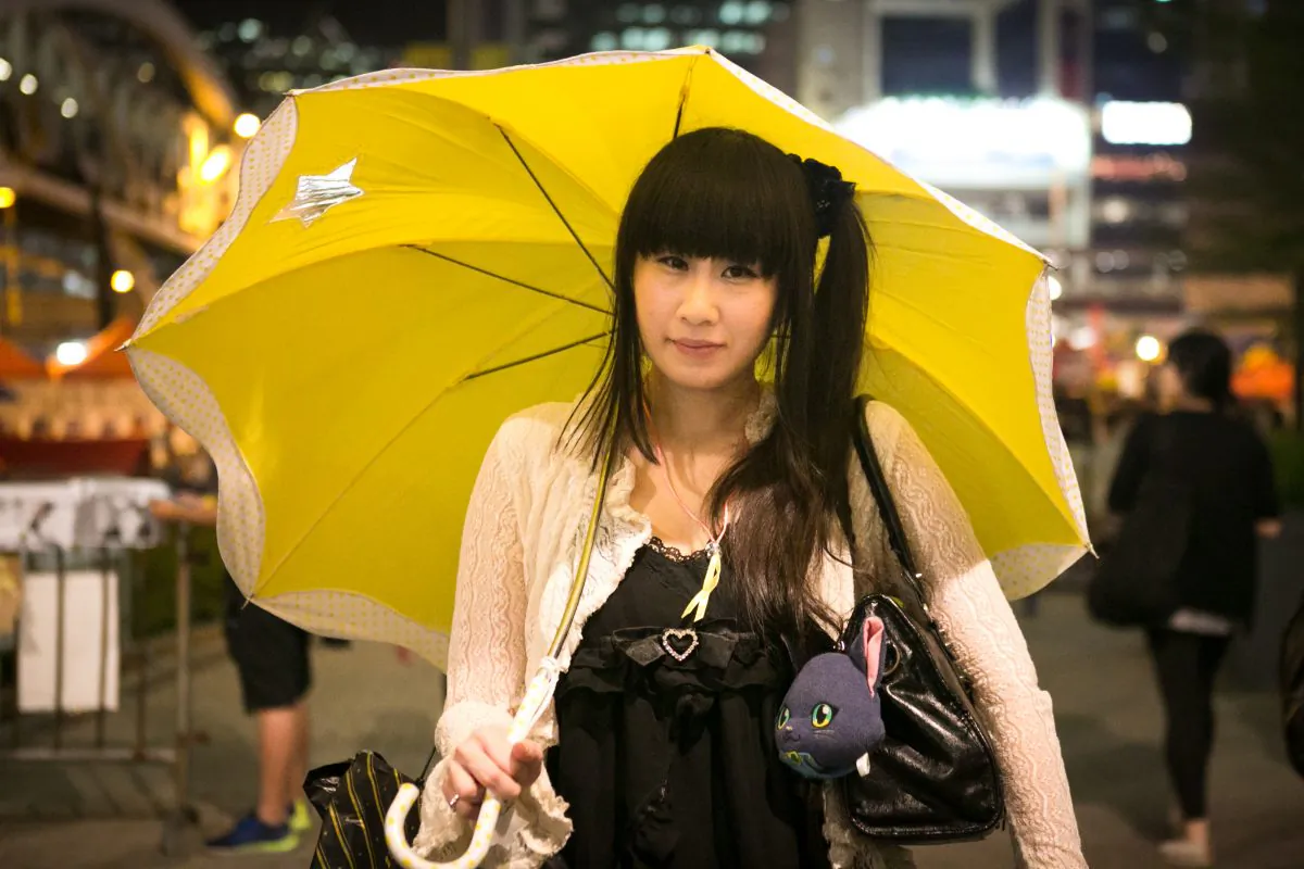 A woman holds a yellow umbrella during a rally on Oct. 28, 2014 marking one month since authorities used tear gas to drive protesters away in the Central District of Hong Kong. (Benjamin Chasteen/Epoch Times)