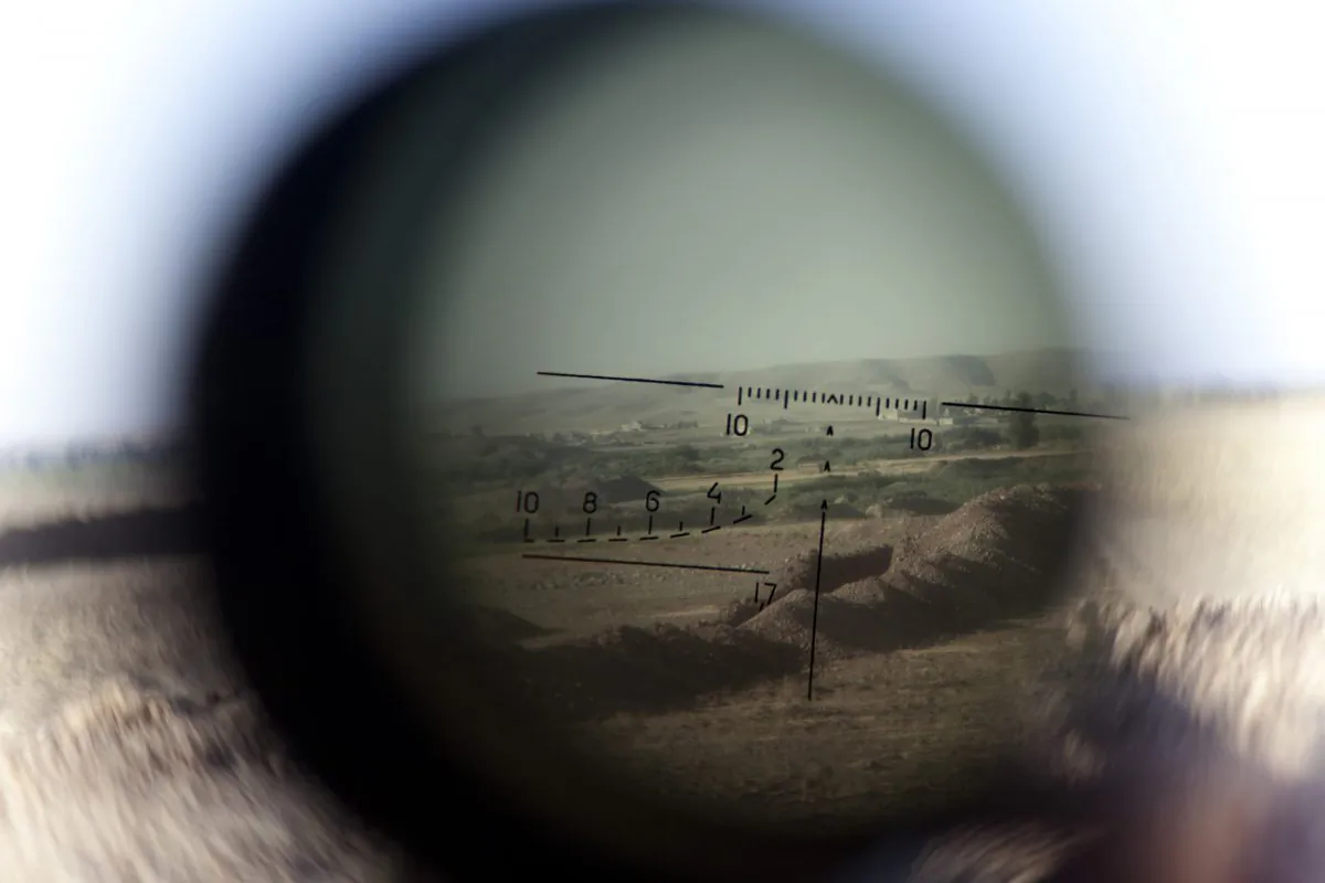 The horizon is seen through a telescopic rifle belonging to a Kurdish Peshmerga sniper on the front line in the Gwer district, 40 kilometres south of Arbil, the capital of the Kurdish autonomous region in northern Iraq, on Sept. 15, 2014. (J.M. Lopez/AFP/Getty Images)