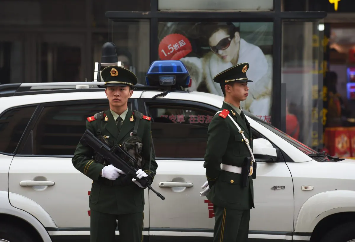 Chinese police officers watch over pedestrians in the Wangfujing shopping district in Beijing on Oct. 24, 2014. (Greg Baker/AFP/Getty Images)