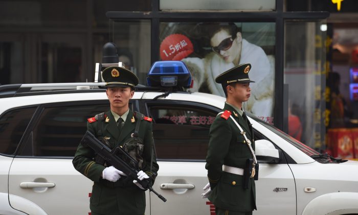 Chinese police officers watch over pedestrians in the Wangfujing shopping district in Beijing on Oct. 24, 2014. (Greg Baker/AFP/Getty Images)