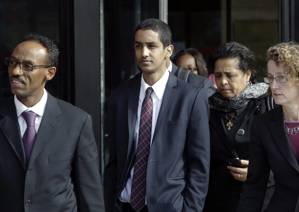 Robel Phillipos (C) departs federal court with defense attorney Derege Demissie (L) after he was convicted in Boston Tuesday, Oct. 28, 2014, on two counts of lying about being in the dorm room of Boston Marathon bombing suspect Dzhokhar Tsarnaev three days after the bombing in 2013, while two other friends removed a backpack containing fireworks and other potential evidence. (AP Photo/Stephan Savoia)