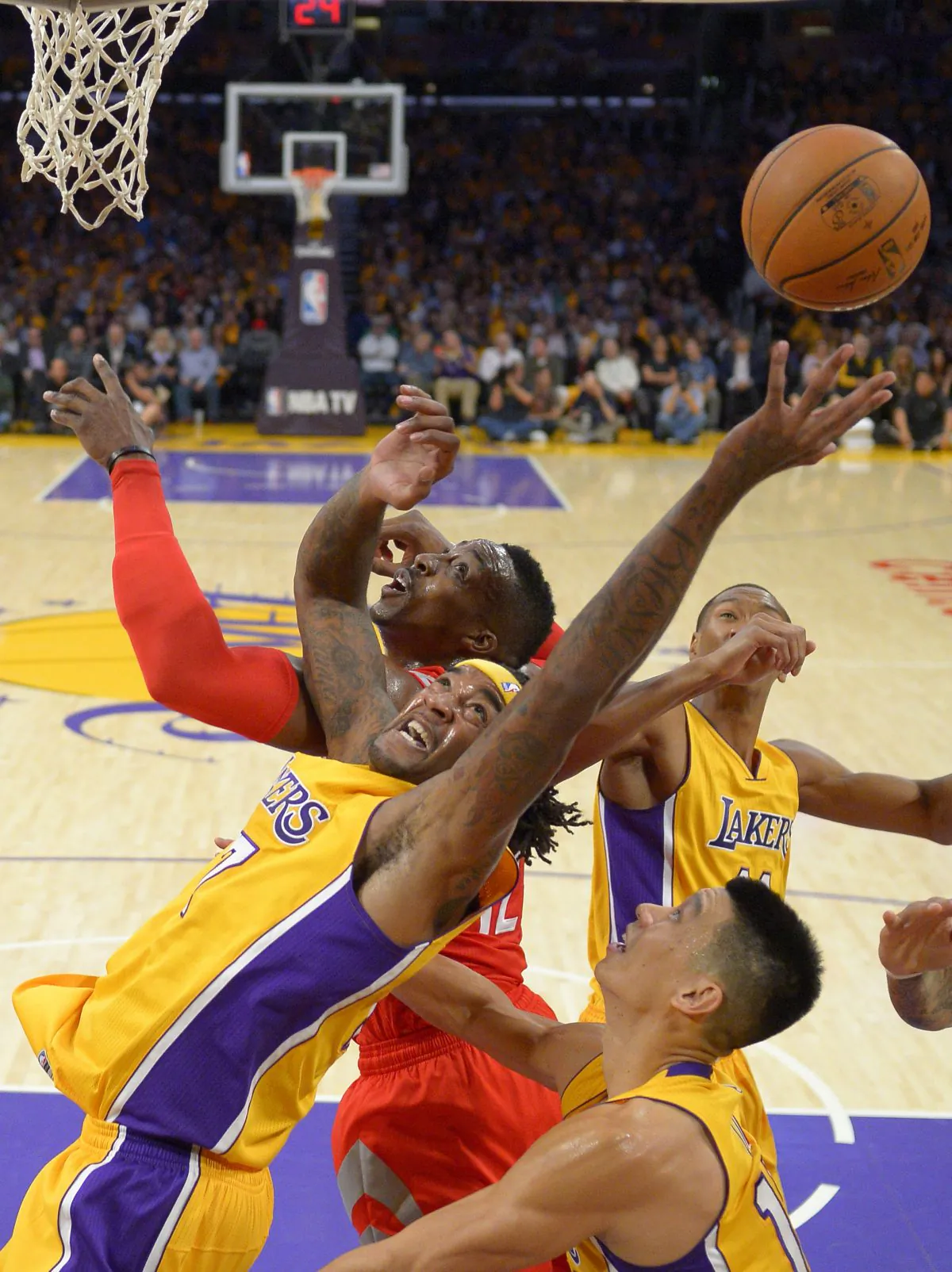 Los Angeles Lakers forward Jordan Hill, left, and Houston Rockets center Dwight Howard, top, battle for a rebound along with guard Jeremy Lin, lower right, and forward Wesley Johnson during the first half of an NBA basketball game, Tuesday, Oct. 28, 2014, in Los Angeles. (AP Photo/Mark J. Terrill)