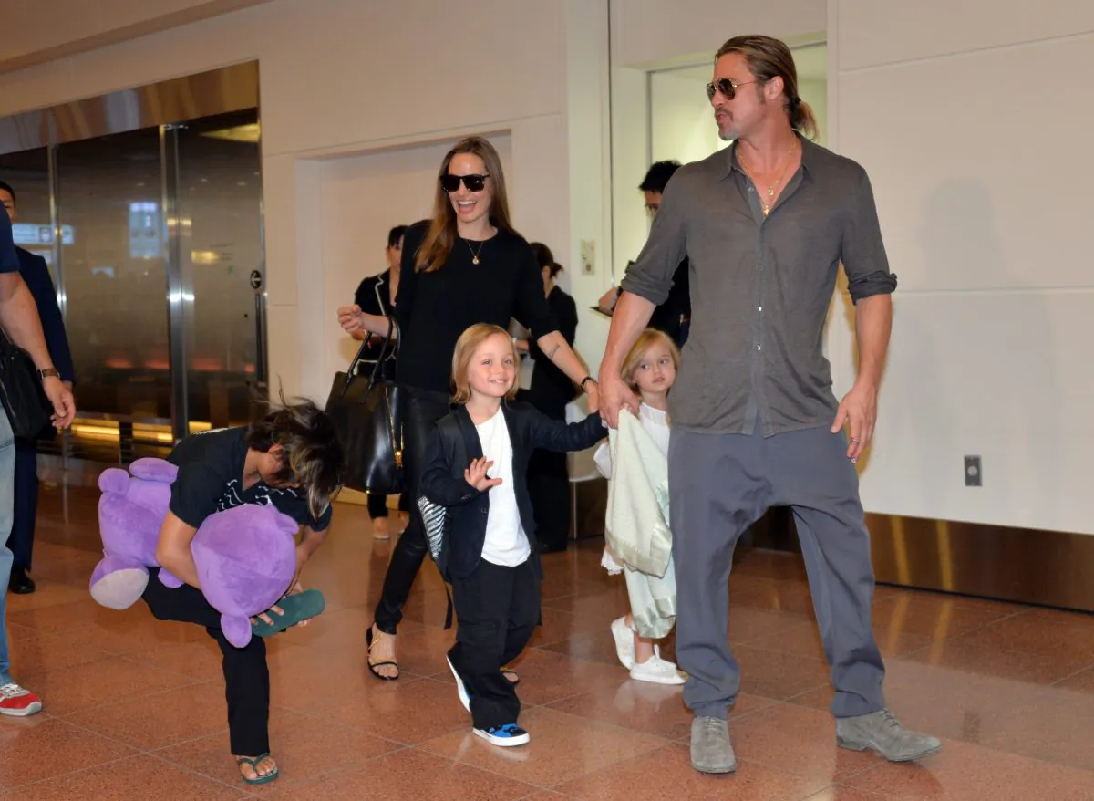 US film stars Brad Pitt (R) and Angelina Jolie (C), accompanied by some of their children, arrive at Haneda International Airport in Tokyo on July 28, 2013. Jolie and Pitt agreed to a temporary custody agreement involving their six children on Sept. 30. (AFP/Getty Images)